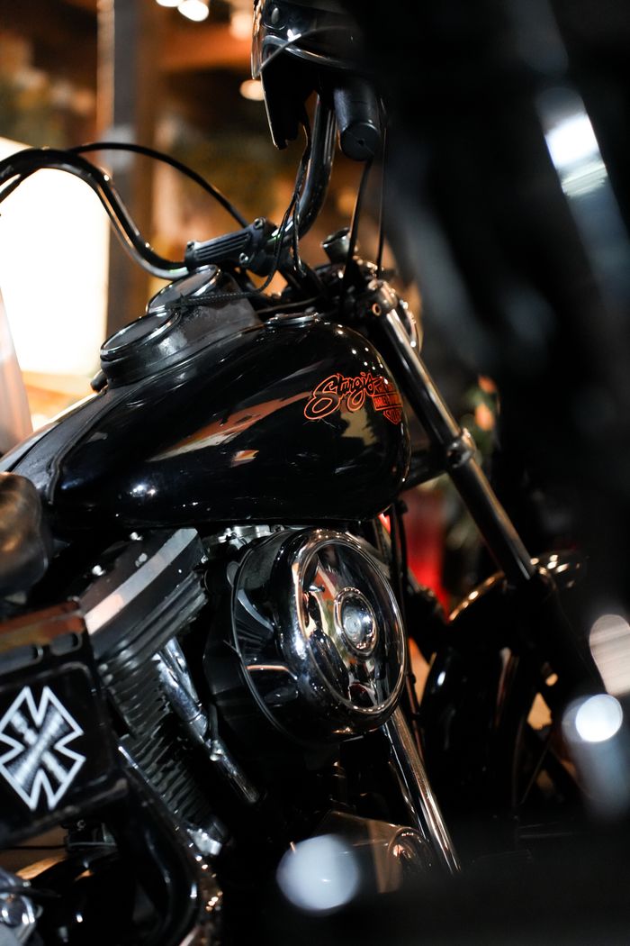 Detailed view of a vintage black motorcycle with polished chrome detailing and logo.